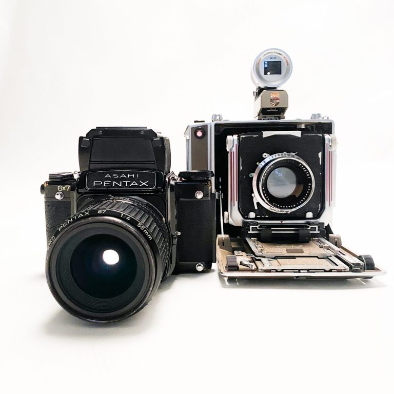 Zwei Kameras: eine analoge Mittelformat links und eine große Plattenkamera rechts.